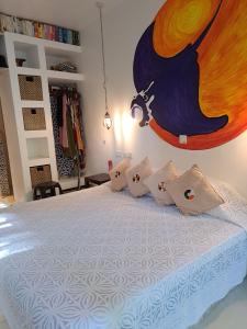 een slaapkamer met een groot bed en een schilderij aan de muur bij Manta Cottage - Forest view in Galu