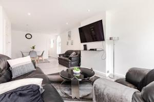 un soggiorno con 2 divani e un tavolo di Lovely 3 bedroom flat in North London a Londra