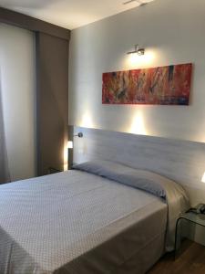 1 dormitorio con 1 cama y una pintura en la pared en CH Hotel San Silvestro, en San Prospero 