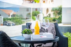 a table with a bottle of beer and a wine glass at Spacious one bedroom apartment Lana in Postira