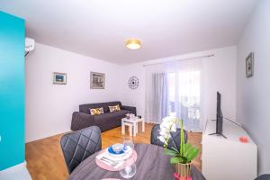 a living room with a table and a couch at Spacious one bedroom apartment Lana in Postira