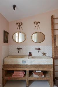 een badkamer met een groot bad en 2 spiegels bij Maisons 322 - La Lumineuse in Le Bois-Plage-en-Ré