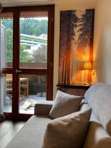uma sala de estar com um sofá e uma janela em Perla di Campiglio em Madonna di Campiglio
