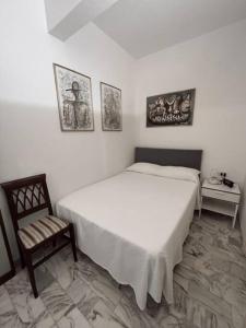 ein Schlafzimmer mit einem großen weißen Bett und einem Stuhl in der Unterkunft Tiberia Apartment in Rom