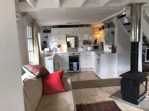 a living room with a stove in a kitchen at Quirky cosy rural hideaway in Swindon