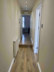 a hallway of an empty room with a hard wood floor at Quiet and cozy 2 SEPERATE BEDROOMS and 2 BATHROOM with terrace in London