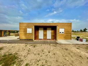 a small wooden building with white doors in a field at Casablanca Village 