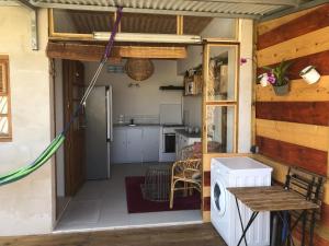 a kitchen and dining area of a house with a washing machine at Bungalow 4 épices in Saint-Leu