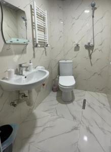 a white bathroom with a toilet and a sink at Hotel Mogzauri, Khulo in Khulo