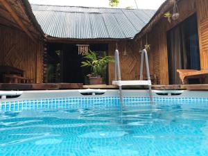- une piscine en face d'une maison dans l'établissement Maison en bambou, éco lodge, à Pila
