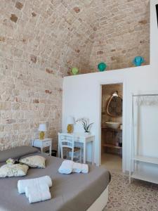 a bedroom with two beds and a brick wall at Dimora Storica Il Tiglio in Castellana Grotte