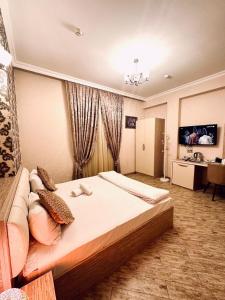 - une chambre avec un grand lit et un canapé dans l'établissement Sebail Inn Hotel, à Baku