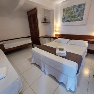 una habitación de hotel con 2 camas en una habitación en Pousada Villegaignon, en Búzios