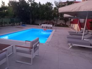 a swimming pool with chairs and an umbrella at Villa Evàlia - Private Villa With Pool -Malakonda ,Eretria ,Greece in Eretria