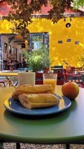 YASI Hostel في ليون: صحن من الخبز وتفاحة وكأس من عصير البرتقال