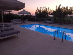 basen z krzesłami i parasolem w obiekcie Villa Evàlia - Private Villa With Pool -Malakonda ,Eretria ,Greece w Erétrii