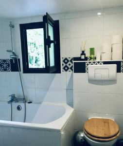 a bathroom with a tub and a toilet and a window at guesthouse bassin d'arcachon à la hume in Gujan-Mestras