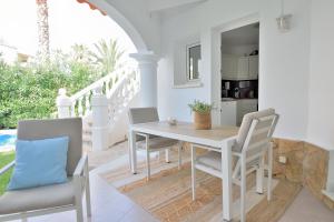 a white dining room with a table and chairs at Villa Renoir in Oliva