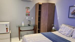Un dormitorio con una cama y una mesa. en Chalé Betel, en Galinhos