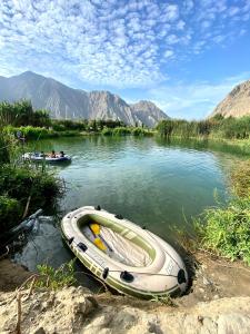 un barco sentado en el agua en un río en La casa de los Viajeros, en Huarmey