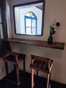 een spiegel en twee krukken in een kamer met een raam bij Mangue House lll in Rio de Janeiro +5 foto's