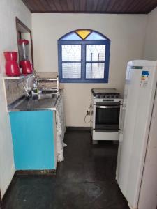 een keuken met een wastafel, een koelkast en een raam bij Mangue House lll in Rio de Janeiro