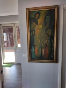 une peinture accrochée à un mur dans une pièce dans l'établissement Gemelli Torrevecchia Apartment, à Rome