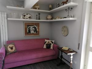 - un salon avec un canapé violet et des étagères dans l'établissement Gemelli Torrevecchia Apartment, à Rome
