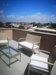 un groupe de chaises et une table sur un toit dans l'établissement Gemelli Torrevecchia Apartment, à Rome