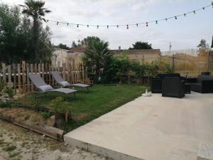 un patio con sedie e un cortile con recinzione di Gite Modes et Café a Épargnes
