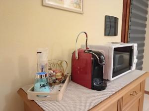 un bancone con forno a microonde e una valigia rossa di La pecorella in vacanza IUN R3384 a Pula