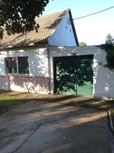 une maison blanche avec deux grandes portes de garage dans l'établissement Sobe Ana, à Sombor