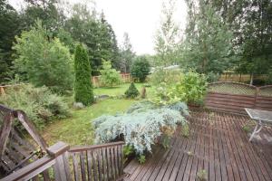 un jardin avec une terrasse en bois et un banc dans l'établissement Omakotitalo 4-6 hengelle - House, à Lahti