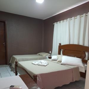 1 dormitorio con 2 camas y toallas. en Pousada Tartaruga en Cumbuco