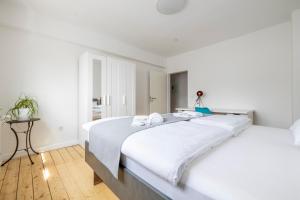 een witte slaapkamer met een groot bed met witte lakens bij Modernes Zuhause - Küche - Top Anbindung - High WLAN in Holzwickede