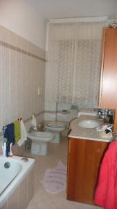 een badkamer met een wastafel, een toilet en een bad bij Casa Daniela in Follonica