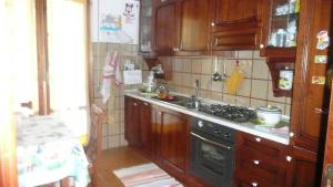 een keuken met houten kasten en een fornuis met oven bij Casa Daniela in Follonica