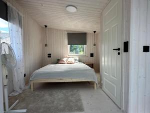 a bedroom with a bed in a room with a window at Fully equipped new tiny-house in Kuressaare