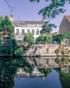 a house on a river in front of a building at B&B Barabas in Bruges