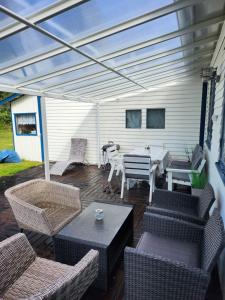 a patio with wicker chairs and a table and a roof at Stuga Ani in Svartå