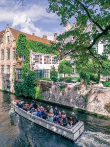 Un gruppo di persone su una barca su un fiume di B&B Barabas a Bruges