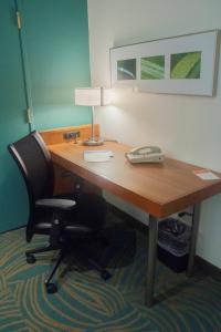 a desk with a phone and a chair in a room at SpringHill Suites Pittsburgh Monroeville in Monroeville