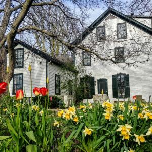 ein weißes Haus mit Blumen davor in der Unterkunft Woodbourne Inn in Niagara on the Lake