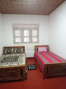 twee bedden naast elkaar in een slaapkamer bij Kitula family guest house in Anuradhapura