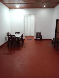 um quarto com uma mesa e cadeiras e uma televisão em Kitula family guest house em Anuradhapura