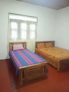 um quarto com 2 camas e uma janela em Kitula family guest house em Anuradhapura
