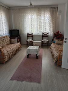 a living room with two couches and a tv at Çetin apart in Ezine