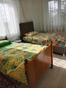 two twin beds in a bedroom with windows at Çetin apart in Ezine