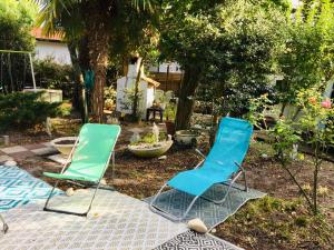 two blue and green chairs sitting in a yard at guesthouse bassin d'arcachon à la hume in Gujan-Mestras