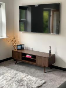 a living room with a coffee table and a mirror at Mill Bank Apartment in Todmorden